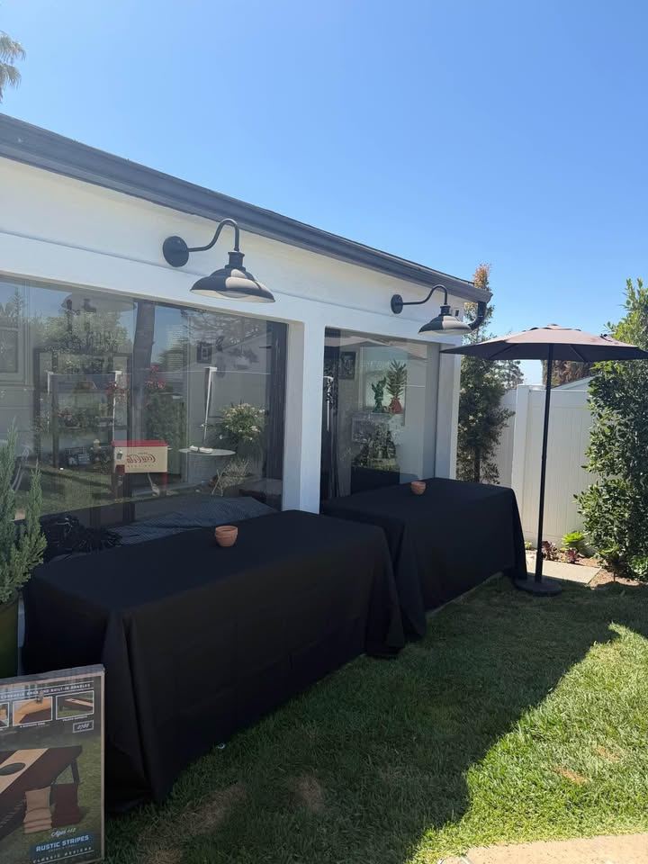 Black-linen tables set beside a house patio